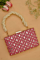 Pink clutch bag with pearl handle on a beige background