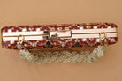 Red clutch with gold accents and pearl details on a beige background