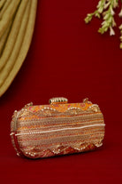 Decorative clutch bag with intricate patterns on a red background