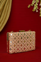 Decorative clutch bag with intricate patterns on a red background