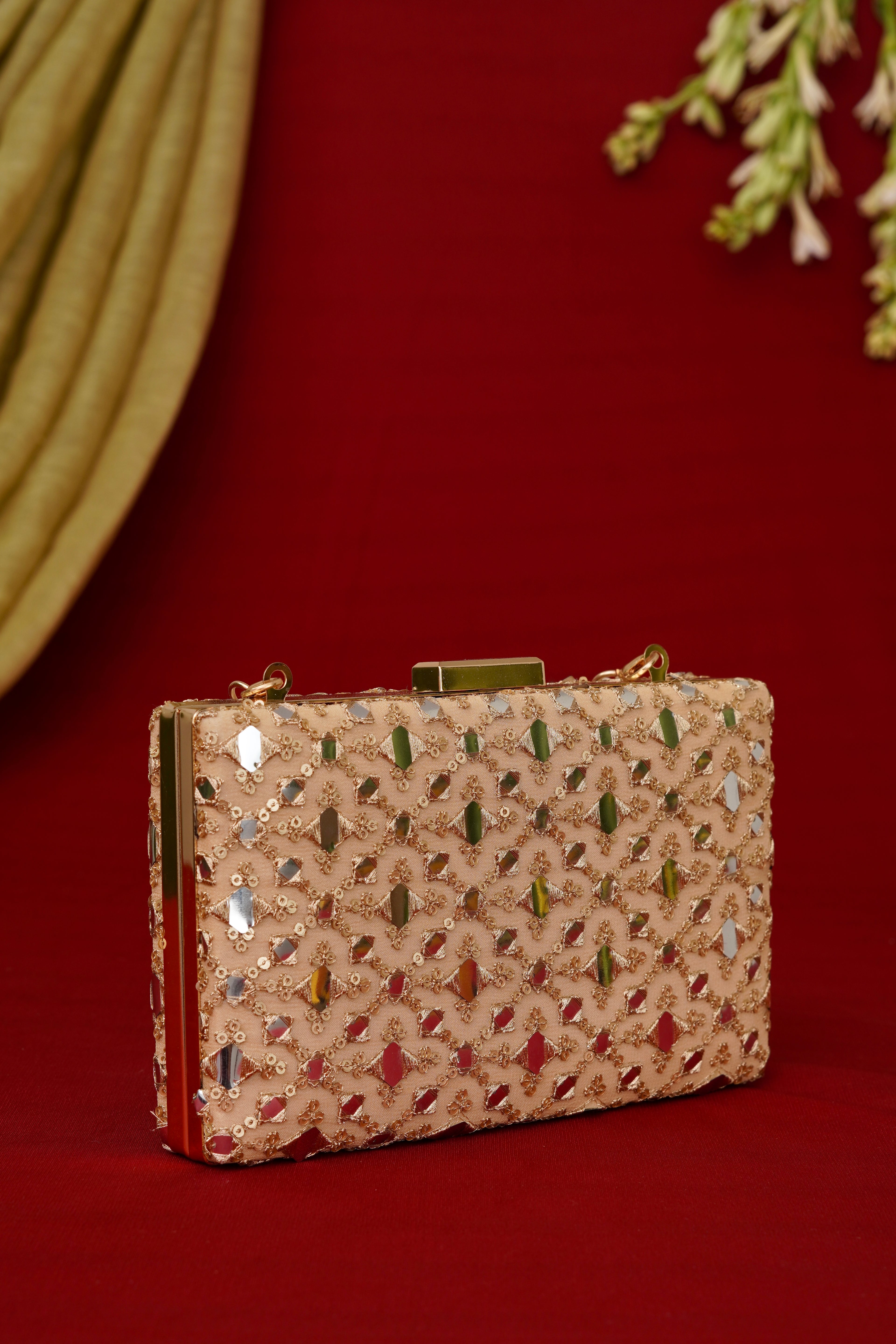 Decorative clutch bag with intricate patterns on a red background